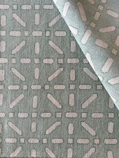 an upholstered fabric with white and pink designs on grey groundcloth, closeup