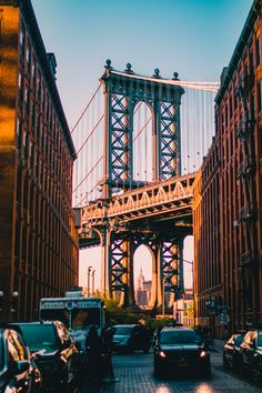 cars are parked in front of the manhattan bridge