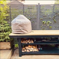 there is a bag on top of the bench next to some firewood and logs