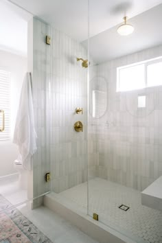 a bathroom with a walk in shower sitting next to a sink and mirror on the wall