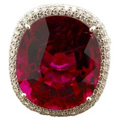 As good as it gets, this gem tourmaline weighs an impressive 18.71 carats. It has a rich intense royal red color with excellent clarity, one of the finest rubellites we have ever seen. It will rival any pigeon blood ruby on the market and its size is no comparison. It is complemented by 1.48 carats of pave-set diamonds set around the tourmaline and down the sides of the ring. Made in 18k white gold, this is an important stone for the distinguished collector. Ring Size 6.50 Weight: 12 grams Rubellite Ring, Blood Ruby, Bling Ideas, Diamond Gold Ring, Rubellite Tourmaline, Gold Rings Fashion, Jewelry Post, Jewels Rings, Tourmaline Jewelry