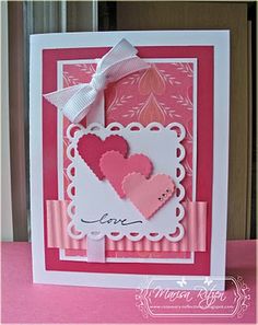 a pink and white card with hearts on it