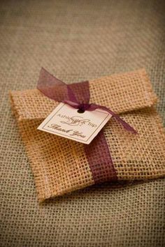 a brown envelope with a purple ribbon tied around it and a tag on the front