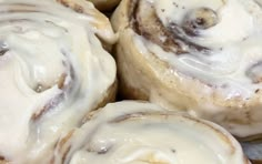 cinnamon rolls with icing sitting on top of each other