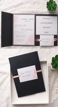 two black and white wedding cards in a box on a table next to some flowers