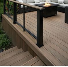 a fire pit sitting on top of a wooden deck next to a couch and table