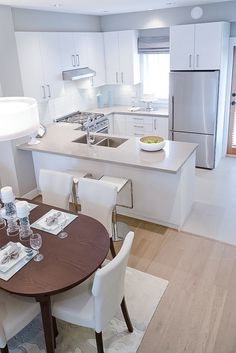 a kitchen with a table, chairs and refrigerator freezer next to an island in the middle