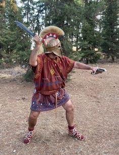 a man dressed in native american clothing holding a baseball bat and wearing an animal headdress