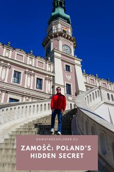 a man in red jacket standing on steps next to a building with a clock tower