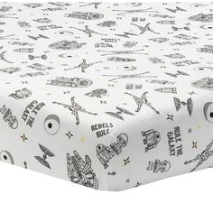 a white bed sheet with black and white cartoon drawings on it's coverlet