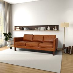 a brown leather couch sitting on top of a white rug