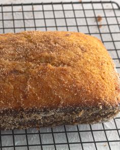 a loaf of bread sitting on top of a cooling rack with powdered sugar over it