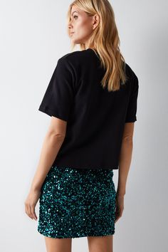 Densely packed sequin embellishments throughout for a glamorous sparkling effect 
 Flattering fitted silhouette with straight hem 
 Fully lined for comfort and ease of wear 
This eye-catching velvet sequin mini skirt from Warehouse is the perfect statement piece for a night out. The fitted silhouette flatters the figure, while the straight hemline shows just the right amount of leg. Embellished from top to bottom in light-catching sequins, this skirt is guaranteed to turn heads. Pair it with a simple cami or sleeveless top to let the skirt be the star of your outfit. For shoes, choose a strappy heel to complement the glamorous look. With special care to protect the delicate sequins, this skirt can transition from the dancefloor to the bar effortlessly all night long. Handle gently and w Christmas Party Shoes, Tanned Makeup, Sequin Mini Skirt, Party Handbags, Velvet Clothes, Sequin Outfit, Christmas Party Outfits, Oasis Fashion, Sequin Mini Skirts