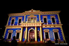 people are standing in front of a building with blue and yellow paint on the side