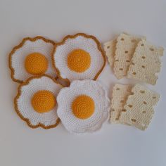 four crocheted fried eggs on top of each other next to two oven mitts