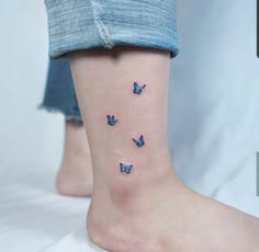 a woman's foot with three blue butterflies on the bottom of her ankle,