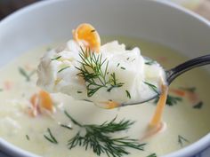 a spoon full of soup with carrots and cream