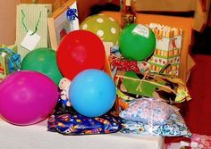 many balloons and presents are on the table