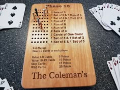 a wooden plaque with the names and numbers of playing cards on it next to some dices