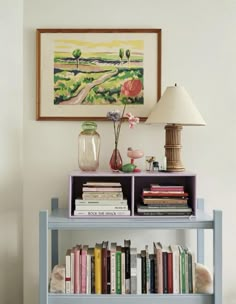 a blue book shelf with books on it and a lamp in the corner next to it