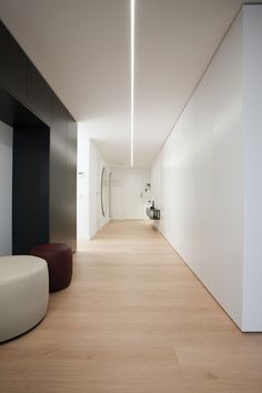 an empty hallway with white walls and wood floors