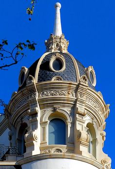 the top of a building with a clock on it's face and a blue sky in the background