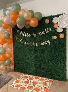 there is a green wall with oranges and balloons