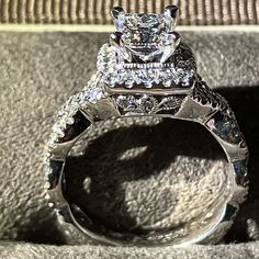 a diamond ring sitting on top of a cushioned surface next to a pair of diamonds