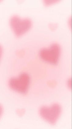 a blurry pink background with hearts on it