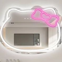 a mirror with a pink hello kitty light on it's side in a room