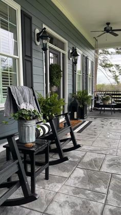 two black rocking chairs sitting on the front porch