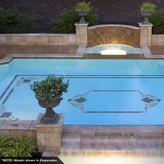 an outdoor swimming pool surrounded by stone steps and planters with potted plants on either side