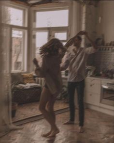 a man and woman dancing in a kitchen