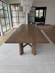 a large wooden table sitting on top of a white rug