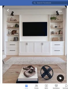 a living room with white built in cabinets and a flat screen tv