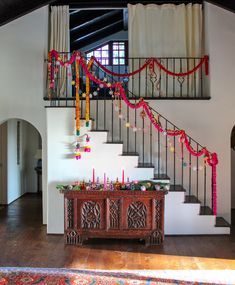 a staircase decorated with flowers and candles in front of a wooden table on the floor