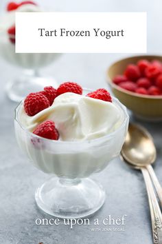 a bowl filled with yogurt and raspberries on top of a table