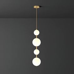 three lights are hanging from the ceiling in a room with dark walls and flooring