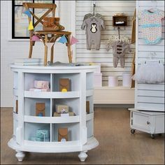 a baby's room with white furniture and toys on the shelves in front of it