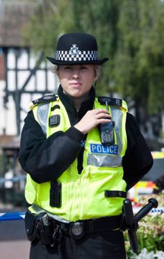 a police officer standing in the street with his hand on his shoulder and looking at something