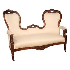 an ornate wooden bench with white fabric upholstered on the armrests and back