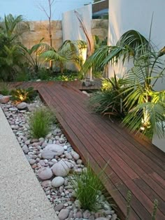 a wooden deck surrounded by plants and rocks