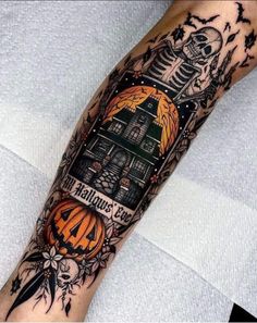 a person with a tattoo on their arm that has an image of a house and pumpkins