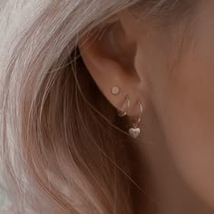 a close up view of a woman's ear with two small hearts on it