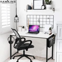 a desk with a laptop computer on top of it next to a chair and window