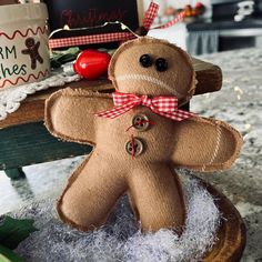 a brown teddy bear sitting on top of a wooden table next to a christmas tree