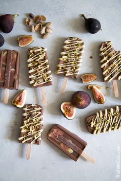 an assortment of popsicles and figs on a white surface with some sliced up