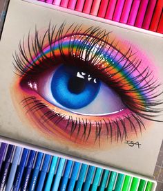 a drawing of an eye with colored pencils next to it