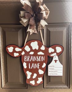 a door hanger decorated with a cow's head and the name branon lane