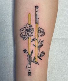 a tattoo with flowers and two candles on it